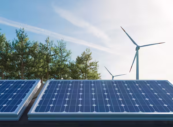 Solar panels and wind turbines on a roof.